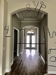 an entry way with lines drawn on the wall and wood flooring in front of it