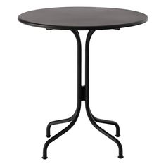 a round table with black metal legs and an iron base, against a white background