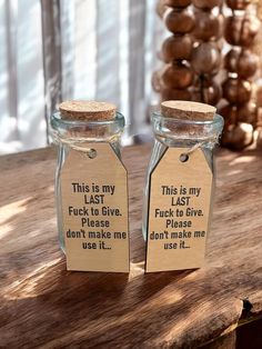 two glass jars with labels on them sitting on a table