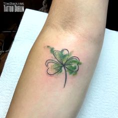 a green clover tattoo on the arm