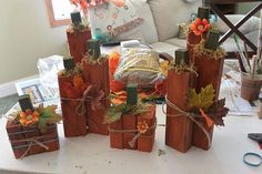 four wooden blocks with fall decorations on them sitting on a table in front of a couch