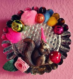 an animal figurine sitting on top of a metal plate covered in colorful ornaments