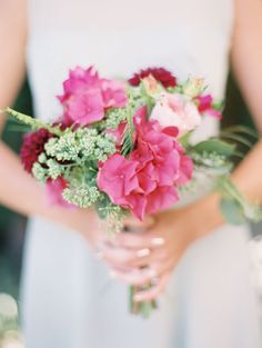 a woman holding a bouquet of flowers in her hands