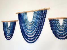 three pieces of blue beads hanging on a wall