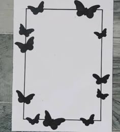 a white paper with black butterflies in the shape of a square on top of it