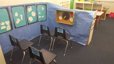 a classroom with several chairs and a blue sheet on the wall that has pictures of children's faces