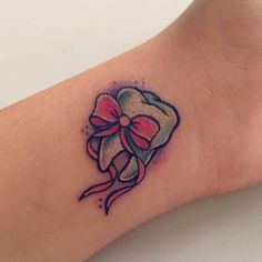 a tattoo with a bow on the wrist