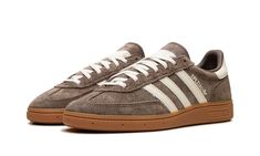 The Women’s adidas Handball Spezial “Earth Strada/Gum” is a women’s-exclusive colorway of the lifestyle shoe with an earth tone color scheme.  The upper is complete with an Earth Strada, or brown, suede construction and contrasted with Cream leather Three Stripes branding on the sides.  Cream “Spezial” and adidas Trefoil logos appear on the lateral side of the mid-panel, while more cream leather can be found on the heel tab.  Underfoot, a gum sole completes the look.  Release date: November 10, 2023 Jordan Dunk Low, Gum Shoes, Mid Jordan 1, Low Jordan 1, Adidas Sl 72, Adidas Handball Spezial, Adidas Handball, All Jordans, Sneakers Box