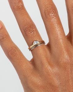 a woman's hand with two rings on it and one ring in the middle