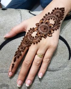 a woman's hand with henna tattoos on it