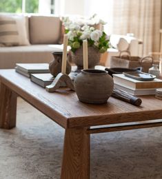 a coffee table with candles and books on it