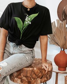 a woman sitting on top of a wooden stool