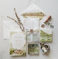 the wedding stationery is laid out on top of an envelope and some other items