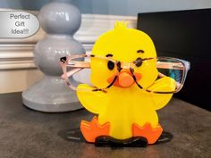 a yellow duck wearing glasses on top of a table