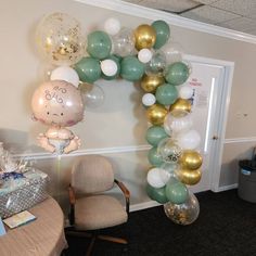 a balloon arch in the shape of a baby's head and feet on a table