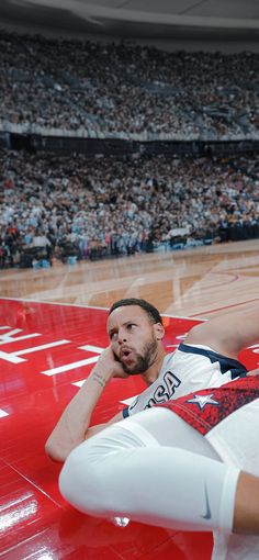 a man laying on top of a basketball court