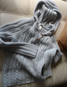 This chunky pullover features the bold fisherman's knit style pattern in a misty gray, with two brown toggle clasps at the neck.  The sweater has a great hoodie, also, and a streamlined, mod look with no ribbed cuffs or waist - just a body skimming "cool factor".  It is tagged Old Navy, L, 65% lambs wool 35% nylon, Made in Indonesia along with registration numbers.  This great piece can be hand washed and dried flat.  It is in very nice vintage condition, and a great buy! The piece is tagged L, but measurements were taken with garment flat and are as follows: Bust - underarm to underarm 17 inches Waist - smallest part of torso across  16 inches Length - front top center neckline edge down front to center hem edge 22 inches Sleeve - underarm seam to edge of wrist 20 inches A FEW MORE DETAIL Cozy Gray Sweater With Buttons, Cozy Warm Gray Sweater, Hooded Sweater With Buttons For Fall, Hooded Button Sweater For Fall, Cozy Hooded Cable Knit Sweater, Cozy Chunky Knit Hoodie, Mod Look, Wool Hoodie, Misty Grey