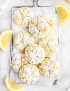 lemon crinkle cookies with powdered sugar and fresh lemons on the side