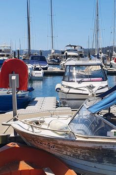 many boats are docked in the water near each other and one boat is blue with red on it