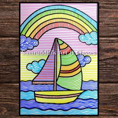 a card with a sailboat and rainbow in the background on a wooden table top