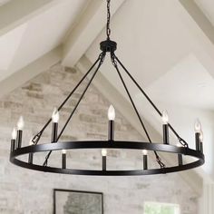 a large chandelier hanging from the ceiling in a room with exposed beams and brick walls