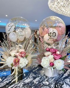 two vases filled with flowers and balloons