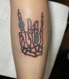 a tattoo on the leg of a woman with an image of a hand holding a turquoise stone