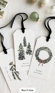 three christmas gift tags with the words merry christmas written on them next to some ornaments