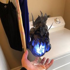 a person is holding something in front of a washer with blue flames on it