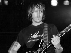 black and white photograph of a man playing an electric guitar