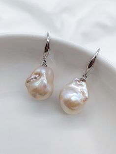 A beautiful new style in our earrings collection. These unique baroque pearls display intense natural colours which are exquisite and varied under different light and angles.  Pearls will vary between each pair of earrings as they are a natural product.   The pearl measures approximately 15mm *20mm * Baroque pearls & Rhodium plated sterling silver With a branded white jewellery box and drawstring pouch for safe keeping, your earrings will arrive in a cardboard box and ribbon for safe transit whi Handmade Baroque Pearl Pear-shaped Earrings, Handmade Baroque Pearl Earrings In Pear Shape, Single Baroque Pearl Earring In Pearl White, Handmade Pear-shaped Baroque Pearl Earrings, Baroque Pearl Earrings For Pierced Ears, Baroque Pearl Teardrop Earrings With High Luster, Single Baroque Pearl Teardrop Earring, Teardrop Baroque Pearl Earrings For Pierced Ears, Pearl White Baroque Pearl Earrings For Pierced Ears