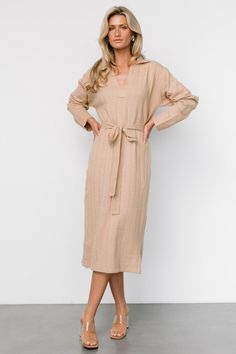 Elevate your fall wardrobe with this preppy tan sweater dress, featuring a cozy rib knit fabric with a stretchy fit and chunky striped ribbing. The collared, notched V-neckline and removable self-tie waist sash add a touch of charm to this versatile piece. Tan Sweater Dress, Cute Sweater Dresses, Rib Knit Fabric, Waist Sash, Tan Sweater, 2024 Style, Cooler Weather, Light Tan, Cute Sweaters