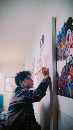 a young man is painting on the wall