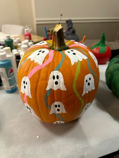 a painted pumpkin with ghost faces on it