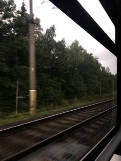 the view from inside a train looking at trees