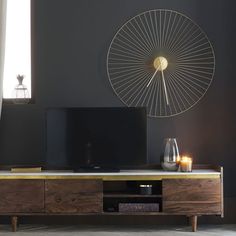 an entertainment center with a large screen tv on it's stand and candles in front of the television