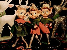 three figurines are standing next to each other in front of a christmas scene