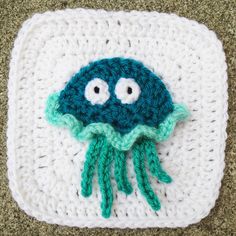 a crocheted square with an octopus on it's face and two eyes