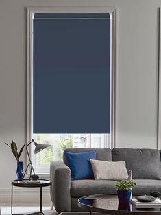 a living room filled with furniture and a window covered in blue shades