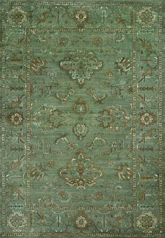 a green rug with an ornate design on the center and sides, in different colors