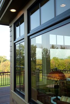 an outside view of a house with large windows and wood decking on the other side