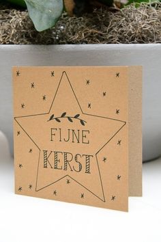 a card with the words fine kerst on it in front of a potted plant