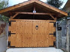 a wooden garage with a metal fence around it