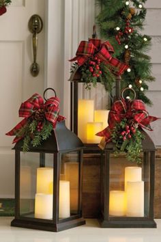 two lanterns with christmas decorations on the front porch