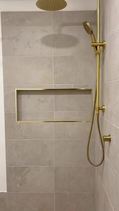 a shower head and hand held shower faucet in a bathroom with beige tile