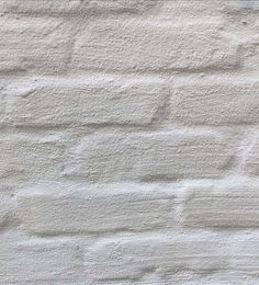 an old white brick wall with no mortar