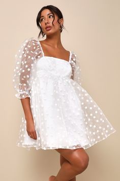 a woman wearing a white polka dot dress