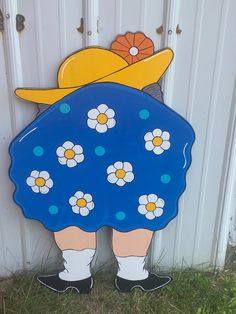 a blue and white flowered dress is standing in front of a door with a yellow duck on it