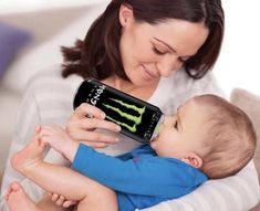 a woman is holding a baby and using a cell phone to play with the monster logo