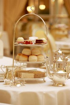 a table topped with two tiered trays filled with pastries and teapots